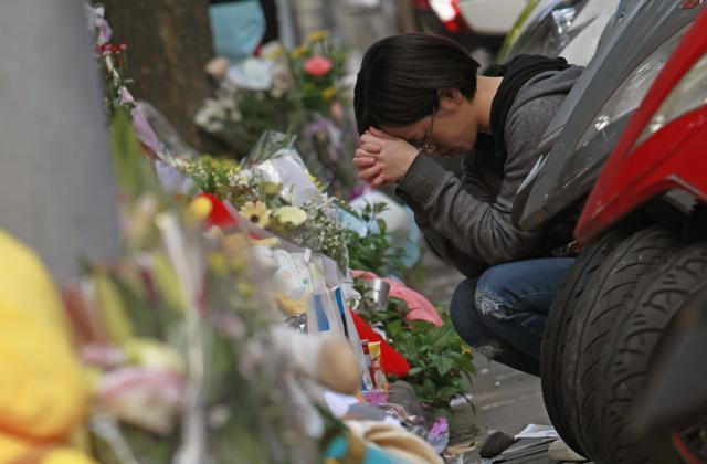 A woman prays in front of a makeshift memorial offered with flowers and stuffed animals for a girl who was attacked to death Monday by a knife-wielding assailant outside a subway station in Taipei, Taiwan. (AP) A woman prays in front of a makeshift memorial offered with flowers and stuffed animals for a girl who was attacked to death Monday by a knife-wielding assailant outside a subway station in Taipei, Taiwan. (AP)