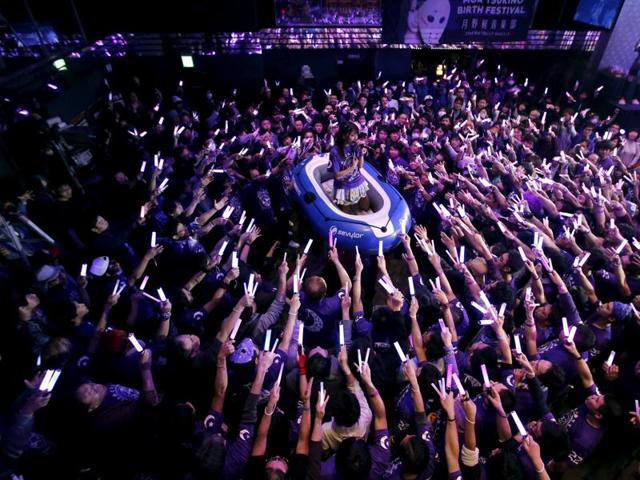 Moa Tsukino (C), a member of Japanese idol group Kamen Joshi (Masked Girls), performs on a raft as fans hold light-sticks during a concert at their theatre in Tokyo's Akihabara district. (REUTERS) 