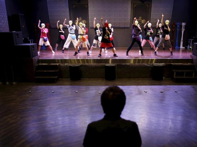 Producer Masaki Nagata (front) watches Japanese idol group Kamen Joshi (Masked Girls) peform during a rehearsal in Tokyo's Akihabara district. (REUTERS) 