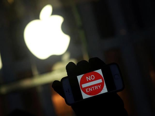 An anti-government protester holds his iPhone with a ‘No Entry’ sign during a demonstration near the Apple store in New York last month.(AFP FILE)