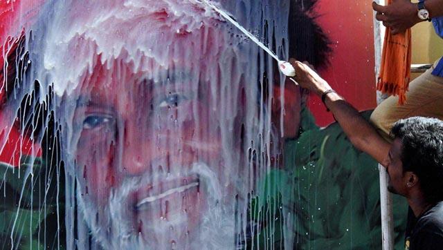 A fan sprays milk on Rajnikanth’s poster on the star’s birthday. (PTI)