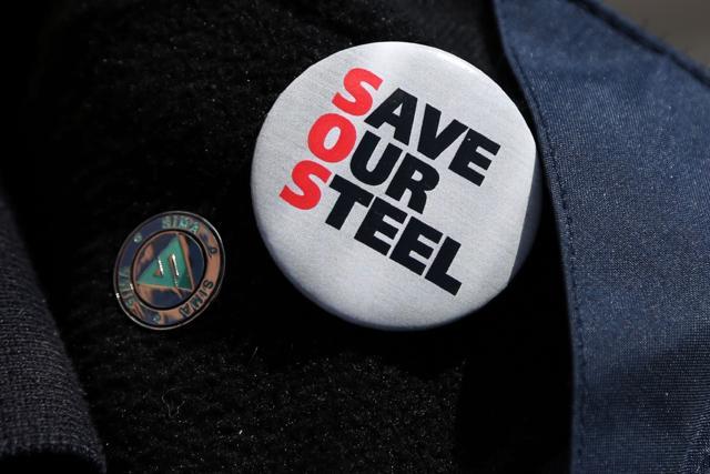 A union worker wears a "Save Our Steel" badge as he speaks during a television interview near the Tata Steel steel plant at Port Talbot, south Wales. (AFP Photo)