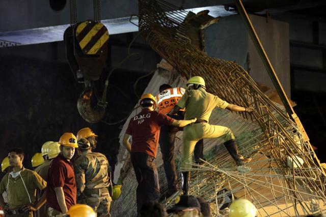 A long section of a road overpass under construction collapsed Wednesday in a crowded Kolkata neighbourhood, with tons of concrete and steel slamming into midday traffic. (AP Photo) A long section of a road overpass under construction collapsed Wednesday in a crowded Kolkata neighbourhood, with tons of concrete and steel slamming into midday traffic. (AP Photo)