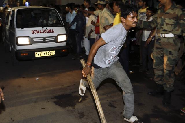 A volunteer clears the way for an ambulance carrying a dead body. (AP Photo) A volunteer clears the way for an ambulance carrying a dead body. (AP Photo)
