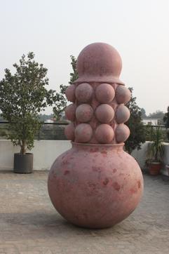Big Maa (in fibre glass, resin and granite dust, 2015). Dimesion: 95 inches X 49 inches X49 inches. Rimzon creates a penis-like totem, anchored in a spherical vessel and adds to it symbols of fertility. The work may be interpreted as a symbol of creation. (NN Rimzon/Talwar Gallery)