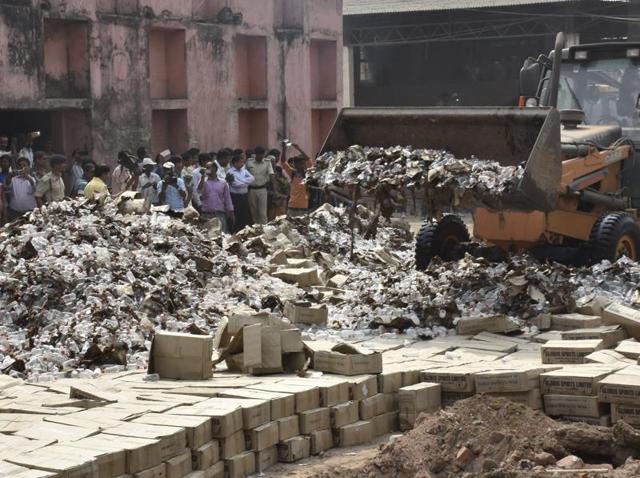 Bottles of country liquor being destroyed on the outskirts of Patna on Thursday.(AP Dube/HT Photo)