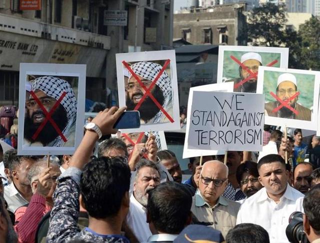 Indian activists carry photographs of the chief of Jaish-e-Mohammad, Maulana Masood Azhar (L) and chief of Pakistan's outlawed Islamic hardline Jamaat ud Dawa (JD), Hafiz Mohammad Saeed (R) during a protest against the attack on the air force base in Pathankot/(AFP Photo)