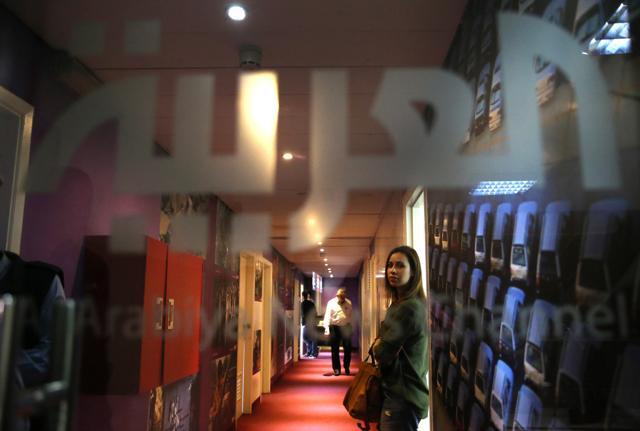 A Lebanese employee at Al-Arabiya channel at her office door in Beirut on Friday. The station shut down its Lebanon operation amid tensions between Riyadh and Beirut. (AP)