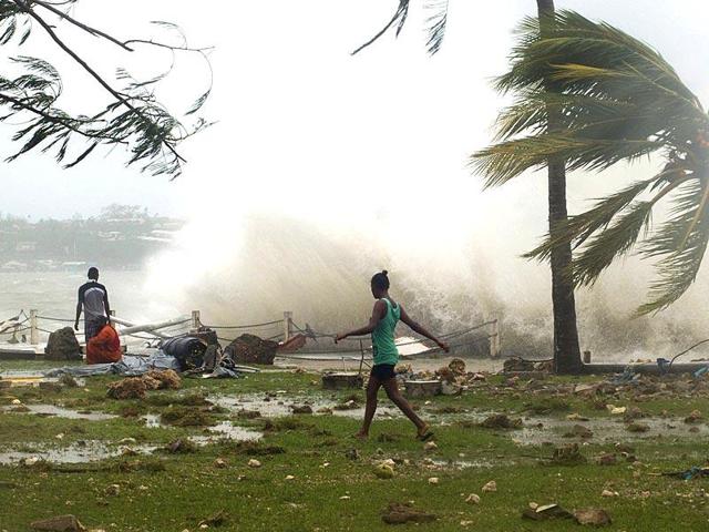 Local residents walk past debris as a wave breaks nearby in Port Vila, the capital city of the Pacific island nation of Vanuatu when a cyclone struck the island last year. (Reuters Photo) Local residents walk past debris as a wave breaks nearby in Port Vila, the capital city of the Pacific island nation of Vanuatu when a cyclone struck the island last year. (Reuters Photo)
