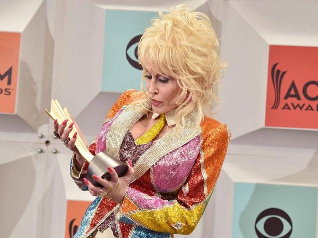Also, Dolly Parton holds the Tex Ritter award in the press room at the 51st annual Academy of Country Music Awards at the MGM Grand Garden Arena on Sunday. (AP)