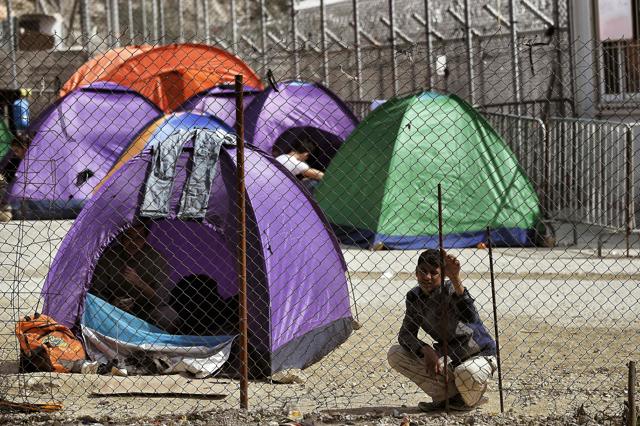 A migrant stands inside the Moria migrant camp transformed in police-run detention facility in Mytilene, on Lesbos island. (AFP)
