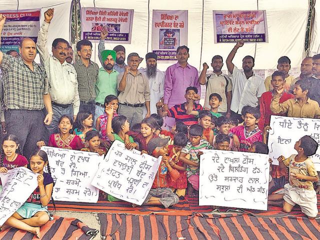 Parents with their children protesting against overcharging of fee by private schools, outside the district administrative complex in Jalandhar on Sunday. (HT Photo) Parents with their children protesting against overcharging of fee by private schools, outside the district administrative complex in Jalandhar on Sunday. (HT Photo)