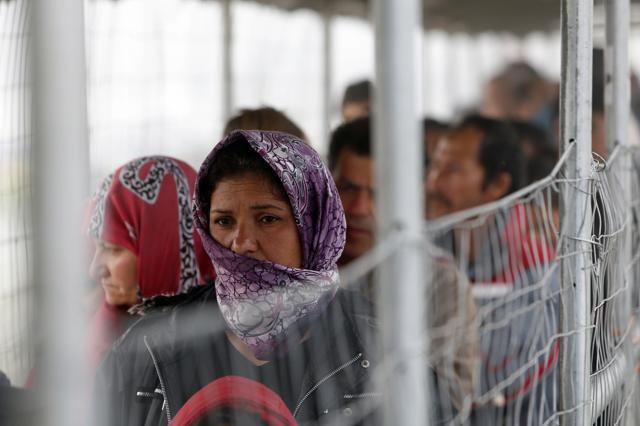 A migrant woman waits in a line to get food at the makeshift camp in the northern Greek border point of Idomeni, Greece. (AP Photo) A migrant woman waits in a line to get food at the makeshift camp in the northern Greek border point of Idomeni, Greece. (AP Photo)