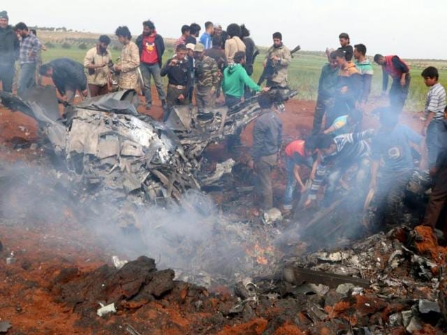 Rebel fighters and civilians gather around the wreckage of a Syrian warplane that was shot down in the Talat al-Iss area, south of Aleppo. (REUTERS) Rebel fighters and civilians gather around the wreckage of a Syrian warplane that was shot down in the Talat al-Iss area, south of Aleppo. (REUTERS)