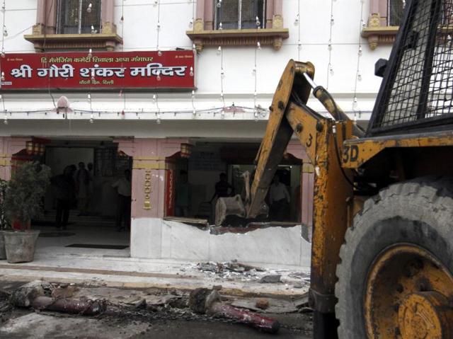 An MCD crane removes a wall of a temple at Chandani Chowk. (Sanchit Khanna/HT Photo) 