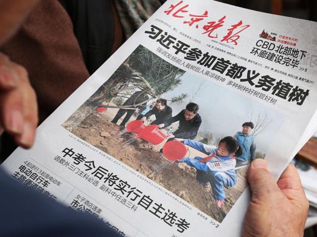 A man reads a newspaper featuring a front page photo of Chinese leaders including President Xi Jinping (C) attending a tree planting ceremony, at a news stand in Beijing. (AFP Photo) A man reads a newspaper featuring a front page photo of Chinese leaders including President Xi Jinping (C) attending a tree planting ceremony, at a news stand in Beijing. (AFP Photo)