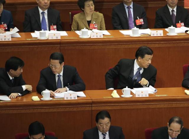 Chinese Communist Party Politburo Standing Committee members Liu Yunshan, second from right, and Zhang Gaoli, second from left, chat with other members during a plenary session of the National People's Congress at the Great Hall of the People in Beijing. (AP) Chinese Communist Party Politburo Standing Committee members Liu Yunshan, second from right, and Zhang Gaoli, second from left, chat with other members during a plenary session of the National People's Congress at the Great Hall of the People in Beijing. (AP)