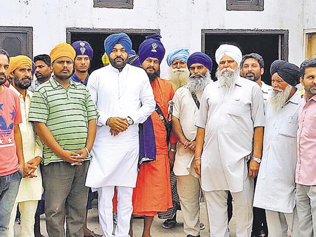 The three youths (extreme left) who were allegedly beaten up by the police with Congress leader Gurjit Aujla (centre) at Bhittewad village in Amritsar on Wednesday.(HT Photo)