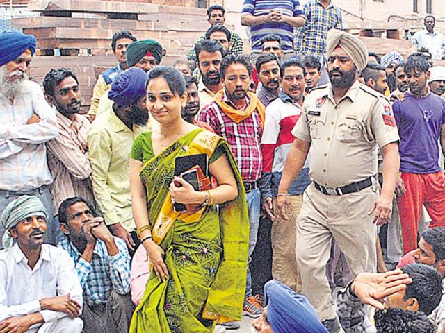 Municipal commissioner Sonali Giri walking past protesting workers on her joining day in Amritsar on Wednesday. She is the first woman MC commissioner of the city. Sameer Sehgal/HT (Sameer Sehgal/HT Photo)