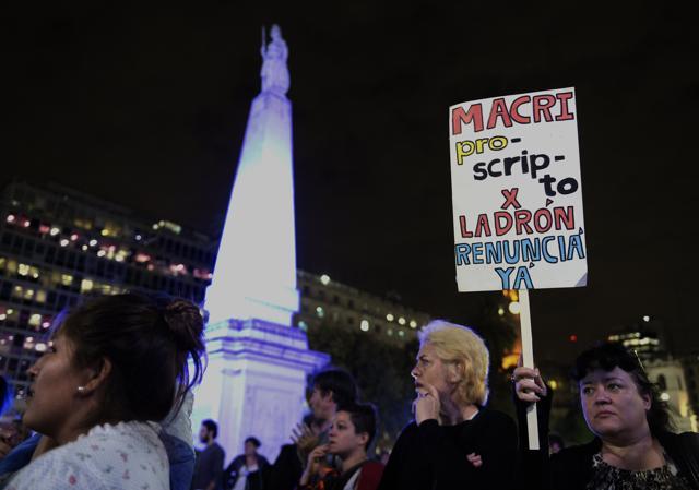 A woman holds a sign reading "Macri outlaw for thief. Resign now" at Mayo square in Buenos Aires during a demonstration. (AFP) A woman holds a sign reading "Macri outlaw for thief. Resign now" at Mayo square in Buenos Aires during a demonstration. (AFP)