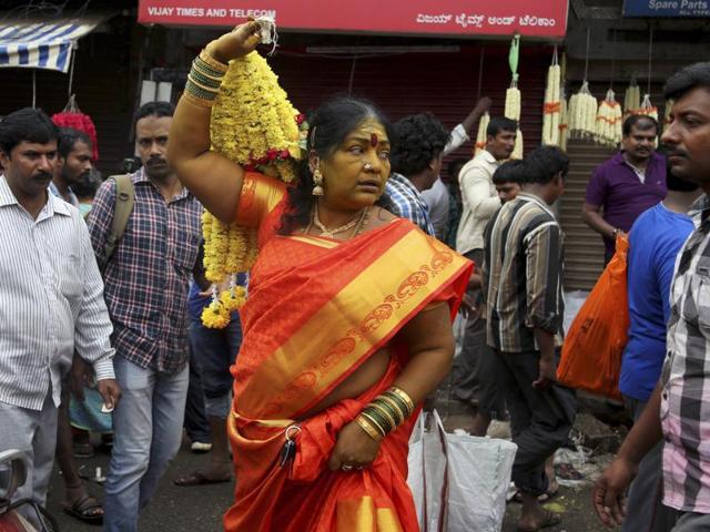 Woman in traditional attire carries a bunch of flowers after shopping at a wholesale market on the occasion of Ugadi in Bangalore. (AP)