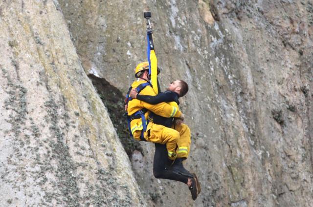 In this photo provided by Bob Isenberg, Michael Banks is rescued after being stranded on a ledge some 80 off the ground on Morro Rock, a landmark in Morro Bay, Calif. (AP) In this photo provided by Bob Isenberg, Michael Banks is rescued after being stranded on a ledge some 80 off the ground on Morro Rock, a landmark in Morro Bay, Calif. (AP)