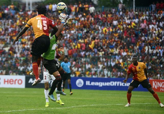 East Bengal's Bernerd Mendy fights for the ball with Mohun Bagan's goalkeeper Debjit Majumder. (AFP Photo) East Bengal's Bernerd Mendy fights for the ball with Mohun Bagan's goalkeeper Debjit Majumder. (AFP Photo)