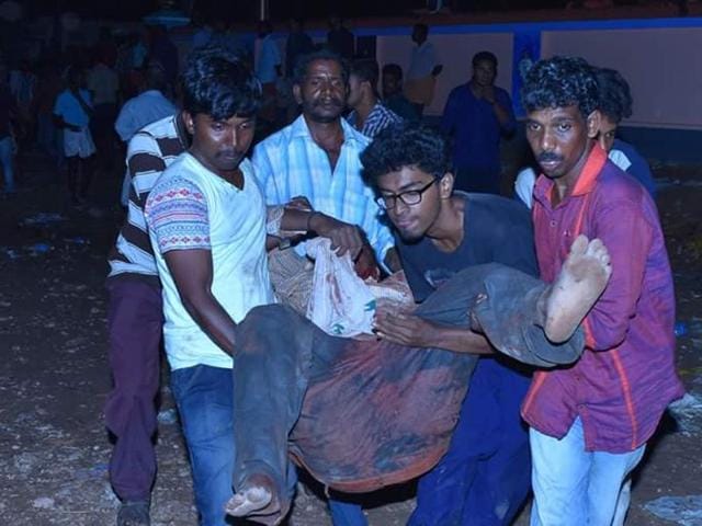 Visitors to the Puttingal temple in Paravur help carry out those injured in the fire to safety. (HT Photo) Visitors to the Puttingal temple in Paravur help carry out those injured in the fire to safety. (HT Photo)