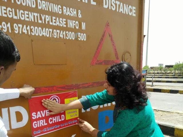 Prof Hemlata Meena pastes a sticker on ‘save girl child’ on a truck in Neemuch on Sunday. (HT photo) Prof Hemlata Meena pastes a sticker on ‘save girl child’ on a truck in Neemuch on Sunday. (HT photo)