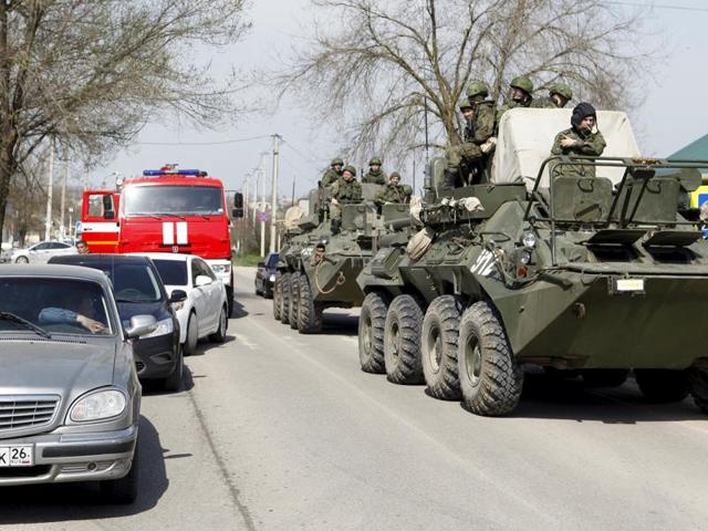 Servicemen of the Russian armed forces ride on armoured vehicles in a settlement of the Novoselitsky district, where a local police station was recently attacked.(REUTERS)