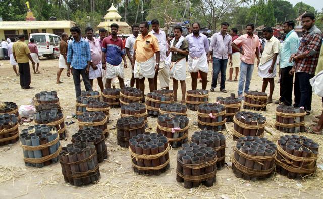 People stand next to empty fire cracker shells inside the compound of a temple after a fire broke out at the temple in Kollam. (Reuters Photo) People stand next to empty fire cracker shells inside the compound of a temple after a fire broke out at the temple in Kollam. (Reuters Photo)