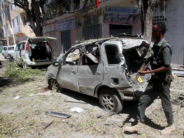 A Somali policeman walks to secure the wreckage of a car destroyed in a bomb explosion at a local government headquarters that killed five people in Somalia's capital Mogadishu. (REUTERS) A Somali policeman walks to secure the wreckage of a car destroyed in a bomb explosion at a local government headquarters that killed five people in Somalia's capital Mogadishu. (REUTERS)
