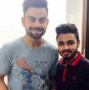 Cricketer Virat Kohli posing with a fan. Kohli is wearing a T-shirt with the tagline ‘We were on a break’. (Photo: Twitter)