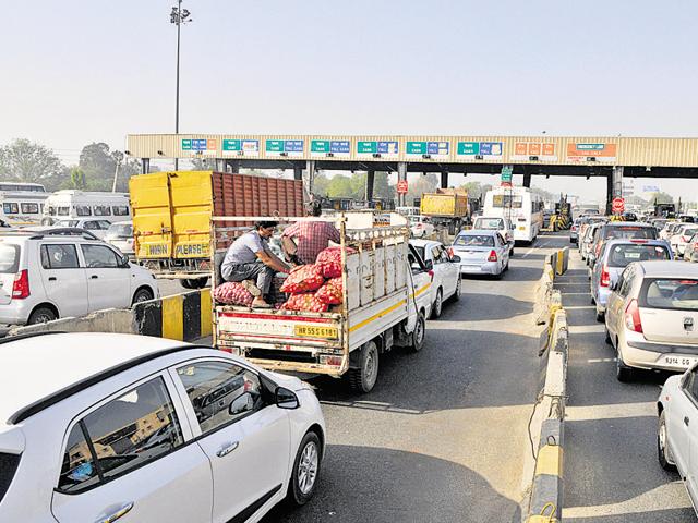 In the absence of separate lanes for commercial and private vehicles, commuters are forced to wait at the toll plaza in long queues. (Abhinav Saha/HT Photo)