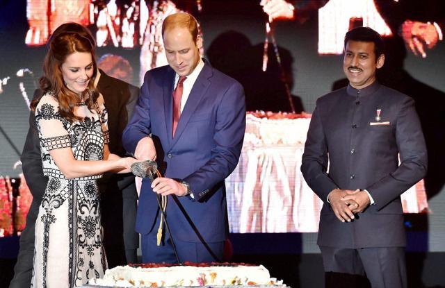 Prince William, Duke of Cambridge(C)and Catherine, Duchess of Cambridge(L)are watched by Rajyavardhan Singh Rathore (R)as they cut a cake during 90th birthday celebrations for Queen Elizabeth II. (AFP) Prince William, Duke of Cambridge(C)and Catherine, Duchess of Cambridge(L)are watched by Rajyavardhan Singh Rathore (R)as they cut a cake during 90th birthday celebrations for Queen Elizabeth II. (AFP)