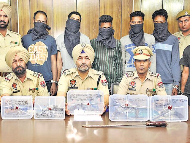 Police officials displaying the wepons seized from accused (in the background) at a press conference in Jalandhar on Monday. (Pardeep Pandit/HT) Police officials displaying the wepons seized from accused (in the background) at a press conference in Jalandhar on Monday. (Pardeep Pandit/HT)