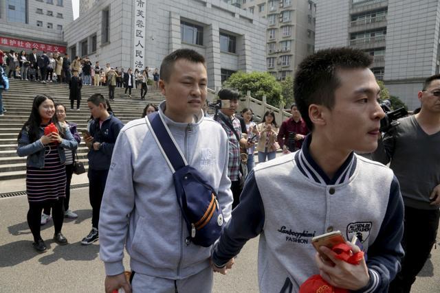 Sun Wenlin, right, and his partner Hu Mingliang leave the court after a judge ruled against them in China's first gay marriage case (AP)