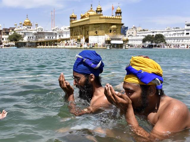 Devotees taking a holy dip at the Golden Temple sarovar in Amritsar on Wednesday. (Gurpreet Singh/HT)