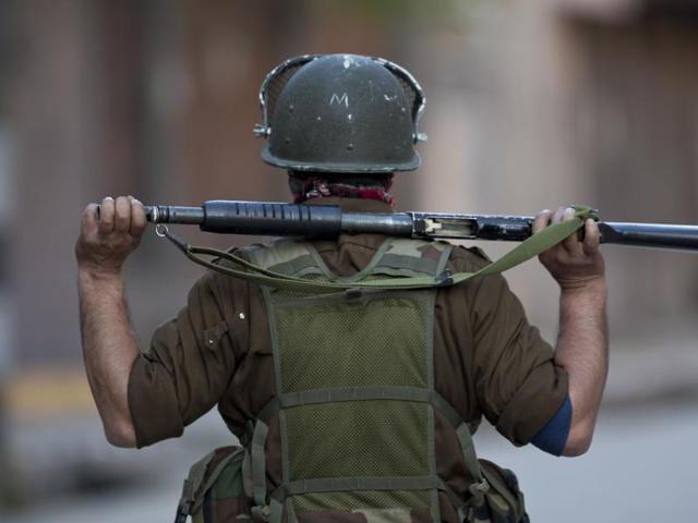 An Indian paramilitary soldier holds a brick before throwing it at Kashmiri Muslim protesters during a protest in Srinagar on April 12, 2016.(AP)