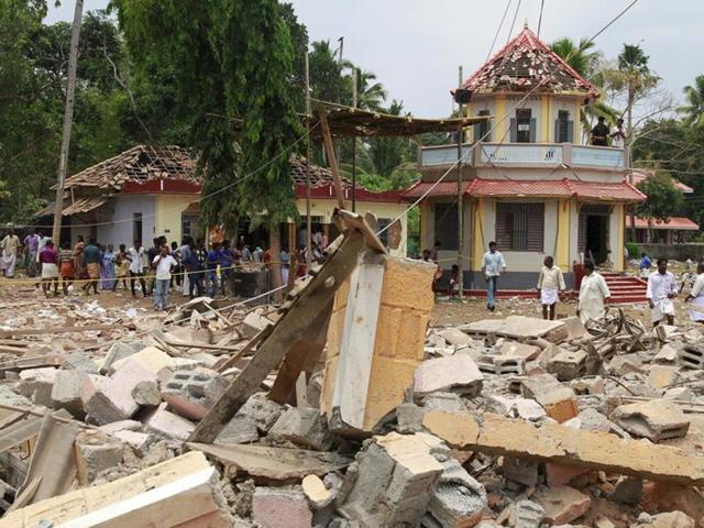 People stand next to debris after a fire broke out at a temple in Kollam, Kerala. (Reuters Photo) People stand next to debris after a fire broke out at a temple in Kollam, Kerala. (Reuters Photo)