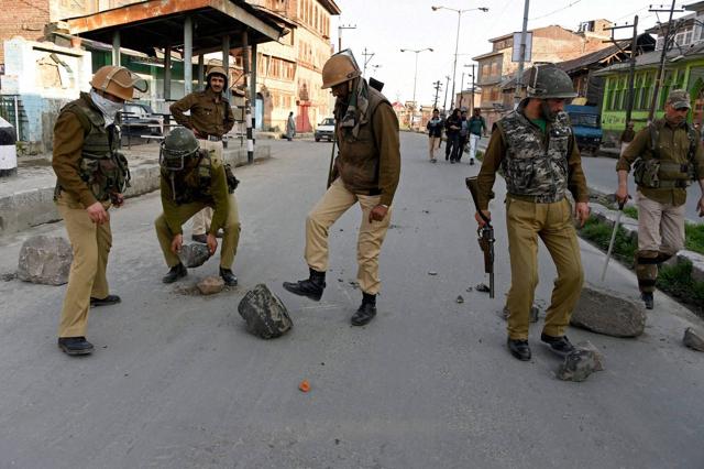 Policemen remove the barricades put up by angry protesters during clashes in Downtown Srinagar on Tuesday. Fresh clashes were reported between residents and the army as the area remained tense. (PTI) 