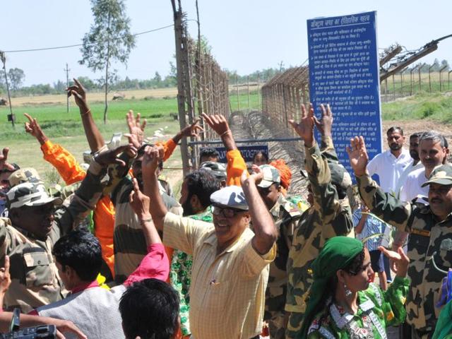 Border Security Force (BSF) personnel along with tourists and artists dancing on the beat of drum at International Border in Jammu. (Nitin Kanotra/HT)