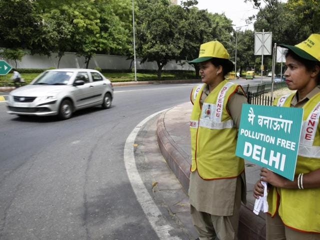 Volunteers remind commuters the reason for restriction placed on vehicle movement in New Delhi, India, Friday, April 15, 2016.(AP)