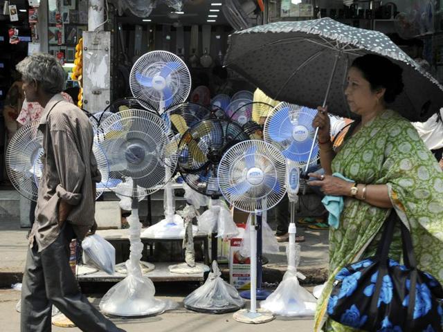 A woman walks past a shop selling fans in Kolkata. Weather officials attribute the early onset of heat to after-effects of the weather phenomenon El Nino that caused poor monsoon last year. (Ashok Nath Dey/HT Photo)