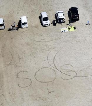 A ‘SOS’ distress signal written on the ground of an elementary school in Aso, Kumamoto prefecture. Mount Aso, the largest active volcano in Japan which is located on Kyushu, erupted for the first time in a month, sending smoke rising about 100 metres (328 feet) into the air, but no damage was reported. It was not immediately clear if there’s a link the seismic activity and the eruption. The 1,592 metre (5,223 foot) high mountain is about 1 ½ hour drive from the epicentre. (AP) A ‘SOS’ distress signal written on the ground of an elementary school in Aso, Kumamoto prefecture. Mount Aso, the largest active volcano in Japan which is located on Kyushu, erupted for the first time in a month, sending smoke rising about 100 metres (328 feet) into the air, but no damage was reported. It was not immediately clear if there’s a link the seismic activity and the eruption. The 1,592 metre (5,223 foot) high mountain is about 1 ½ hour drive from the epicentre. (AP)