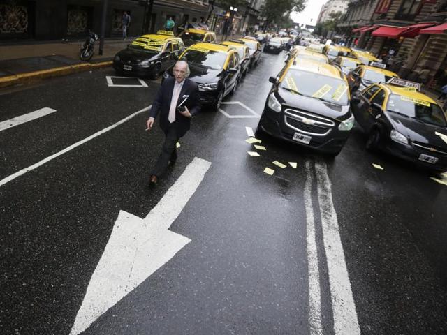 A man walks through taxi drivers blocking an avenue to protest Uber in downtown Buenos Aires, Argentina, Friday, April 15, 2016. Taxi drivers paralyzed parts of Buenos Aires during rush hour against Uber launching its service in Argentina’s capital city in defiance of local authorities. (AP) A man walks through taxi drivers blocking an avenue to protest Uber in downtown Buenos Aires, Argentina, Friday, April 15, 2016. Taxi drivers paralyzed parts of Buenos Aires during rush hour against Uber launching its service in Argentina’s capital city in defiance of local authorities. (AP)
