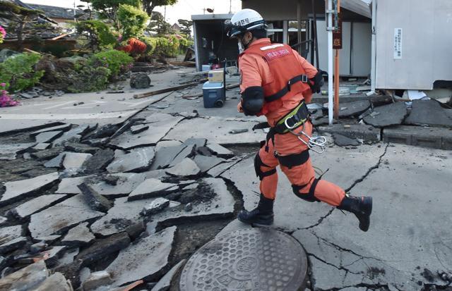 A member of a rescue team runs on a street cracked by the earthquake in Mashiki, Kumamoto prefecture. Saturday’s quake hit residents who were still in shock from the previous night’s earthquake and had suffered through more than 100 aftershocks. (AFP) A member of a rescue team runs on a street cracked by the earthquake in Mashiki, Kumamoto prefecture. Saturday’s quake hit residents who were still in shock from the previous night’s earthquake and had suffered through more than 100 aftershocks. (AFP)