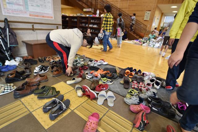 Evacuees take off their shoes at the entrance of a health center in Mashiki, Kumamoto prefecture on April 15, 2016, after a 6.5-magnitude quake struck the southwestern island of Kyushu on April 14. (AFP)