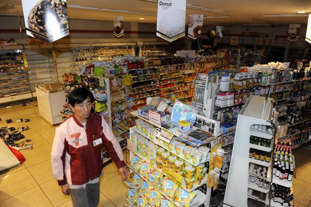 A worker surveys the damage at a 7 Eleven convenient store following an earthquake, Saturday, April 16, 2016, in Kumamoto, southern Japan. (AP)