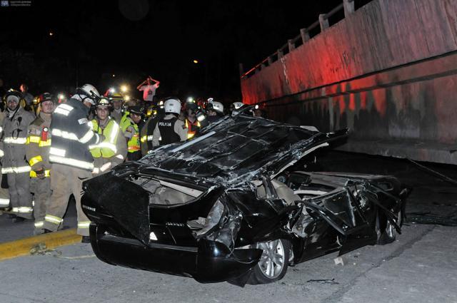 Rescue workers stand beside a destroyed car after a bridge collapsed in an earthquake in Guayaquil, Ecuador. (AFP) Rescue workers stand beside a destroyed car after a bridge collapsed in an earthquake in Guayaquil, Ecuador. (AFP)